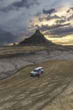 From above an unrecognizable person standing next to a SUV at Factory Butte, Utah, captured during