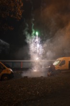 Nocturnal fireworks spectacle on a street with spectators and smoke, Stuttgart Birkach, Germany
