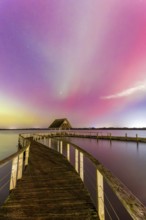 Wooden jetty and Northern Lights, Aurora borealis, polar lights over Lake Hemmelsdorf,