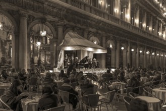 Music orchestra playing in front of the historic Café Florian on St. Mark's Square in the evening,