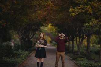 A couple enjoying a beautiful fall day in Quebec, Canada. The woman holds a bouquet of wildflowers,