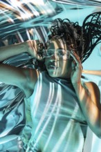 Young African woman immersed in a futuristic metaverse setting, wearing clear high-tech glasses