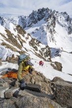Mountaineer belaying on a steep snow slope, belaying on a rope, ascent to the summit of Piz