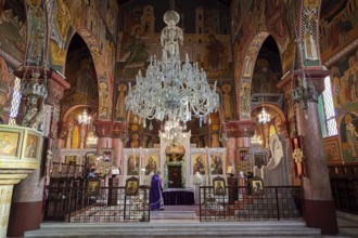 Magnificent altar area with large chandelier and icons in a decorated church, Church of the