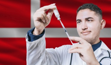 Doctor holding syringe on Denmark flag background. Medical professional holding syringe with Danish