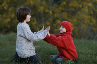 A boy and a girl enjoying a playful moment together in a vibrant autumn park setting, surrounded by