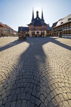 Market square with town hall and long shadow in the backlight, Wernigerode, Harz, Saxony-Anhalt,
