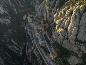 An aerial view of the Montserrat Abbey in Catalonia, Spain, showcases its unique placement amidst