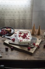 Rustic scene of homemade vanilla ice cream garnished with red currants and berries, served on a