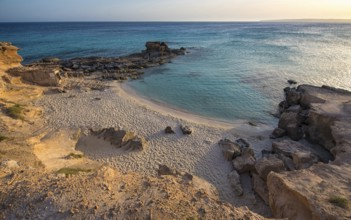 A tranquil beauty of Calo des Mort, Spain, featuring pristine sand and inviting turquoise waters,