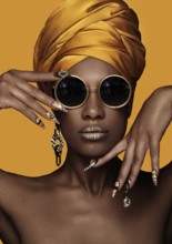 Beautiful black woman with a yellow towel on her head, classic makeup and art manicure. Beauty face