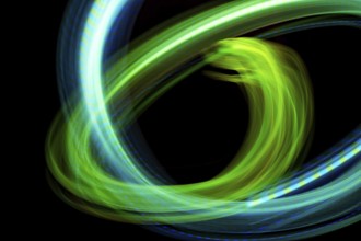 Dynamic abstract image showcasing swirling neon lights in vibrant green and blue hues against a