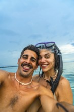 Couple taking a selfie with snorkeling gear in the ocean at white beach, cebu island, philippines,
