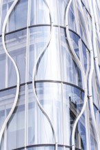 Stunning modern architecture showcasing a sleek, curved glass facade. The reflective surfaces and