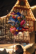 A colourful collection of balloons in front of traditional architecture at a lively Christmas