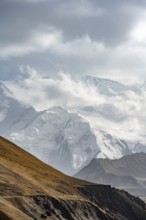 Dramatic mountain landscape, mountain valley, behind glaciated and snow-covered mountain peak Pik
