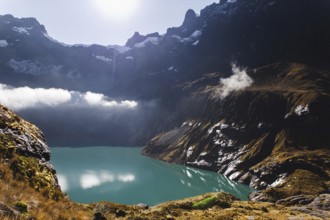 A stunning turquoise crater lake at El Altar volcano, Ecuador, surrounded by rugged peaks, golden