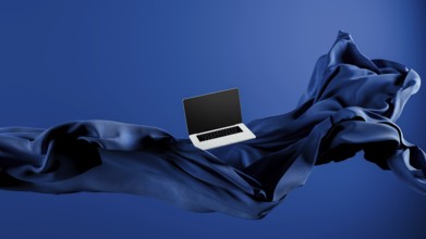 A sleek laptop is placed atop smooth fabric, showcasing its lightweight design against a rich blue
