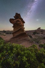 A stunning rock formation stands tall against a backdrop of a starry night sky in Coyote Buttes,