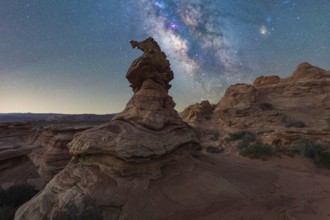 A breathtaking view of a starlit sky over unique rock formations in a desert landscape in Coyote