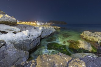Scenic night view of the Mediterranean Sea at Costa Blanca, featuring rugged coastal rocks