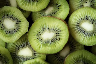 Top view of fresh kiwi slices displaying their vibrant green flesh and dark seeds. The close up