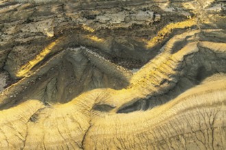 Aerial view of Utah's golden sandstone desert displaying intricate patterns and rich textures. The