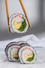 A close up view of sushi rolls with various colorful ingredients like crab, omelette, and greens