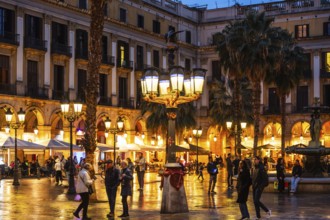Nightlife at Plaça Reial, lanterns by Gaudi in the historic centre of Barcelona, Spain