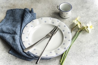 From above, a dining setup featuring a white plate with blue polka dots, accompanied by silverware