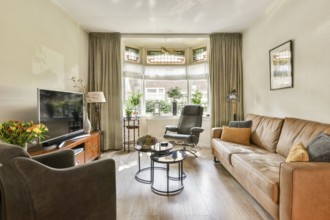 A beautifully arranged living room featuring comfortable furniture, a large window, plants, and