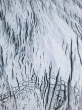 Aerial view of the Icelandic winter terrain, showcasing a dramatic, snow-covered landscape with