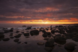Rocky bay under a dramatic glowing sky at the coast. unset, Vigrestad, Rogaland, Norway