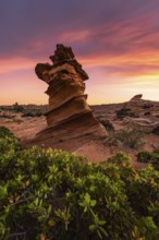 Majestic rock formation stands against a vibrant sunset sky in Coyote Buttes, part of the Paria
