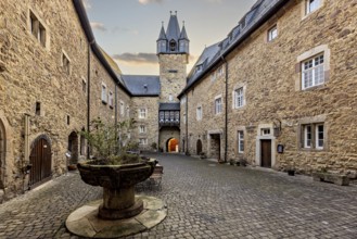 Inner courtyard with a view of a church tower and stone walls in the late afternoon light, The