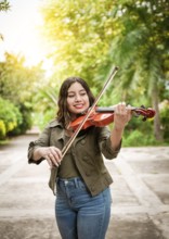 Portrait of a girl playing the violin outdoors, Close up of a girl with her violin playing a melody