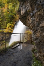 View from a rocky path to a waterfall surrounded by autumn foliage, Lake Brienz, Giessbach