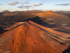 Picturesque volcanic landscape in evening light, red volcano Montaña Bermeja between lava fields,