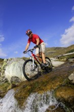 A man on a mountain bike in an alpine landscape
