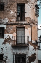 Dilapidated building with weathered balconies and shutters