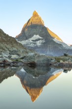 Majestic view of the Matterhorn in the Swiss Alps reflecting in calm waters. The iconic pyramid