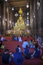 Praying Buddhists at Wat Pho, Temple of the Reclining Buddha, Bangkok, Thailand