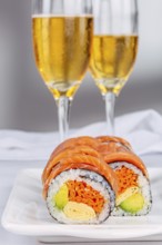 Delicious sushi rolls with salmon, avocado, and omelette are elegantly displayed on a plate,