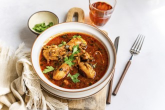 A hearty bowl of Georgian chicken stew, chakhokhbili, immersed in rich tomato sauce with paprika