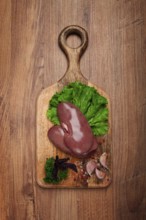 Raw pork kidneys, on a chopping board, close-up, top view, no people