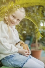 Portrait of adorable girl playing with cavy looking at camera