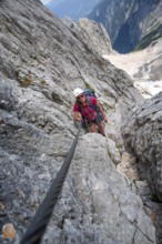 Mountaineer with helmet climbing in a secured via ferrata, Zugspitze via ferrata, ascent to the