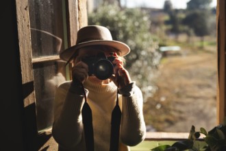 In a cozy countryside home near Barcelona, Spain, a senior unrecognizable woman captures the serene