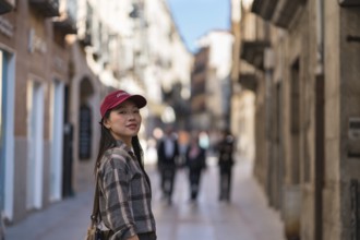 Asian female tourist enjoying a stroll through the historic streets of Avila, capturing the essence