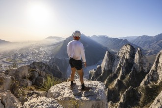 A man stands on a rocky peak at Eagle's Nest in Monterrey, Mexico, taking in the breathtaking view